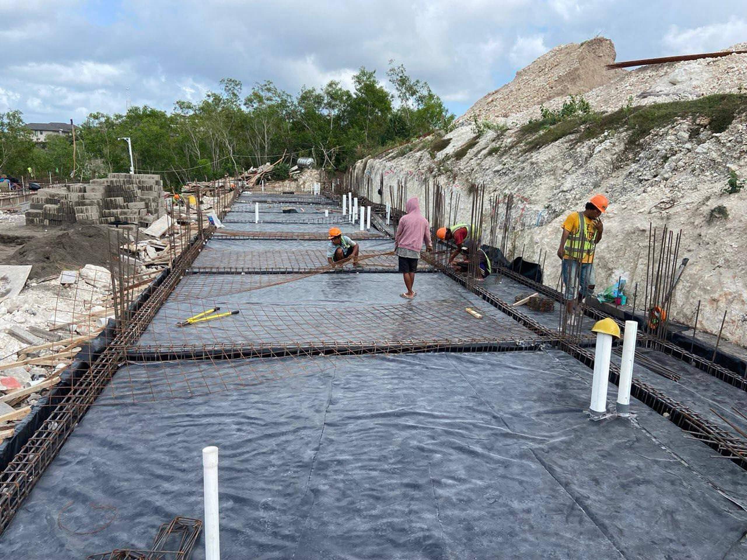Construction progress — foundation slab rebar mesh with workers — Frigate Bali