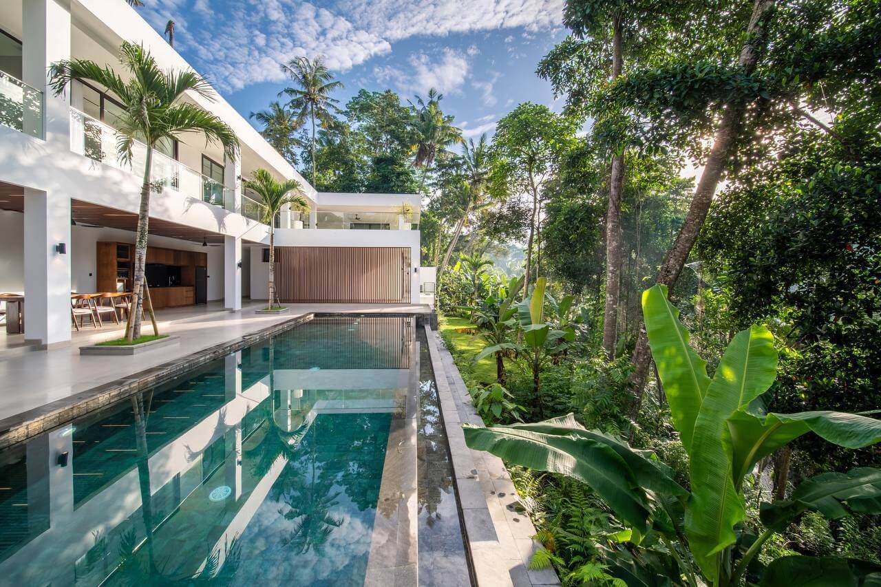 White two-storey villa with long pool beside tropical jungle — Frigate Bali